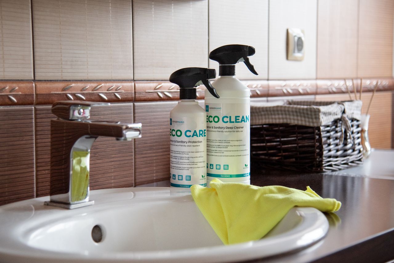 our-value Eco-friendly cleaning products displayed on a bathroom sink with tiles and a basket.