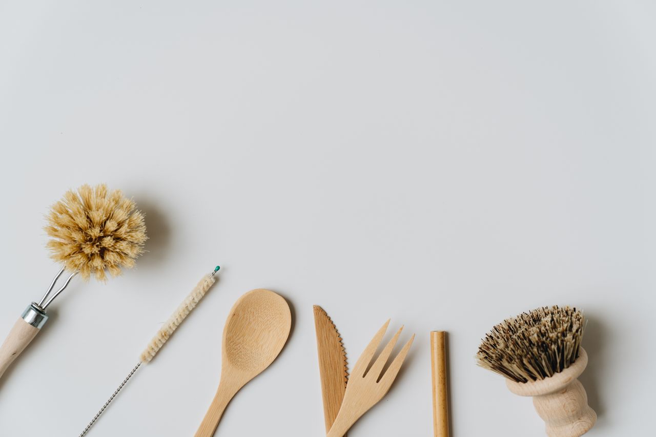 services-03 Sustainable wooden kitchen utensils and brushes on a white background, promoting eco-friendly living.